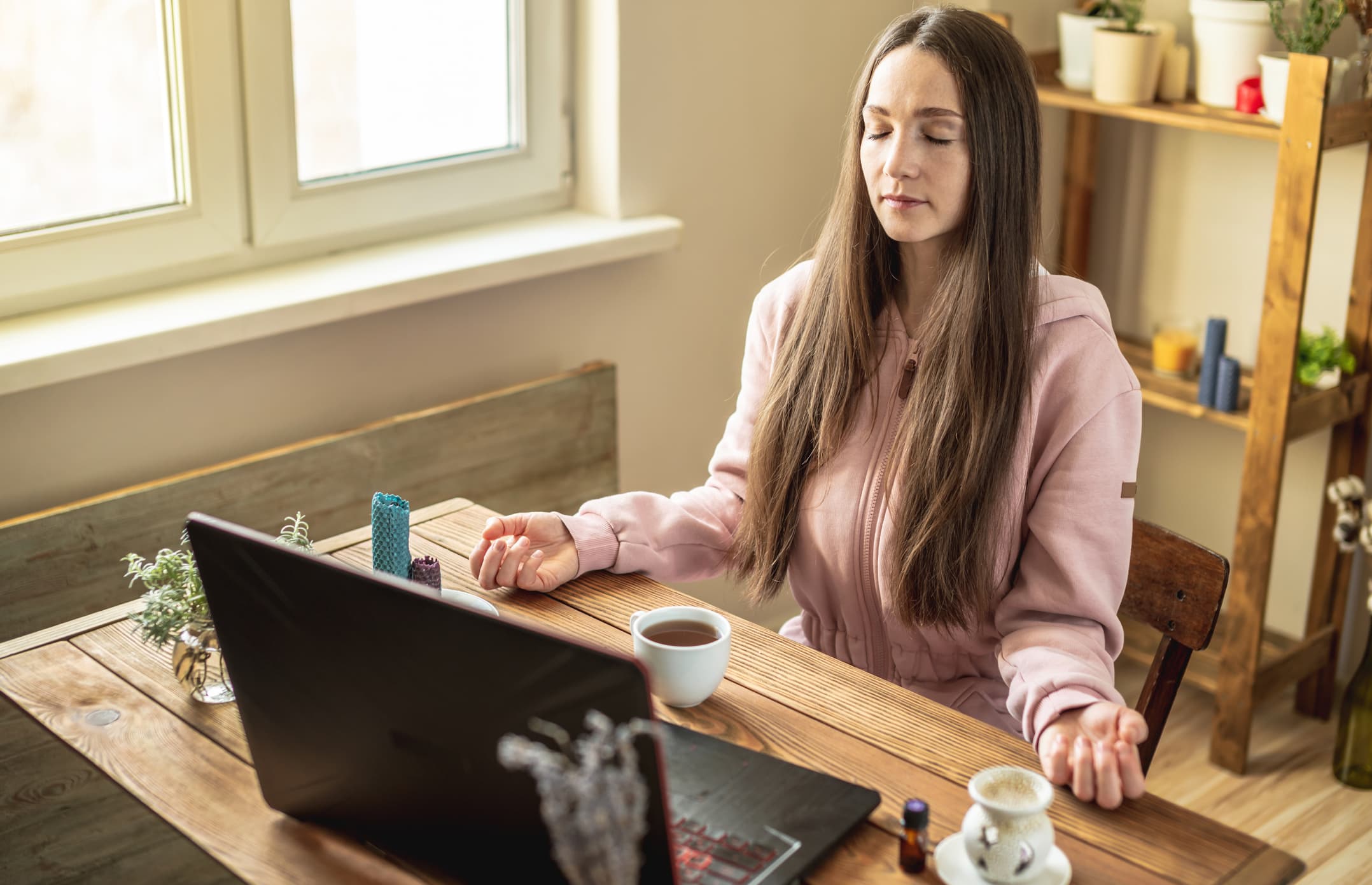 woman meditating while sitting at computer