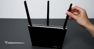 person adjusting antenna on ASUS wifi router