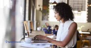 woman using laptop in front of a window at a coffee shop