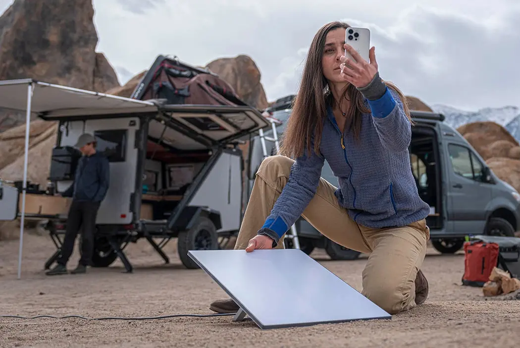 camping woman connects to internet with Starlink Mini.