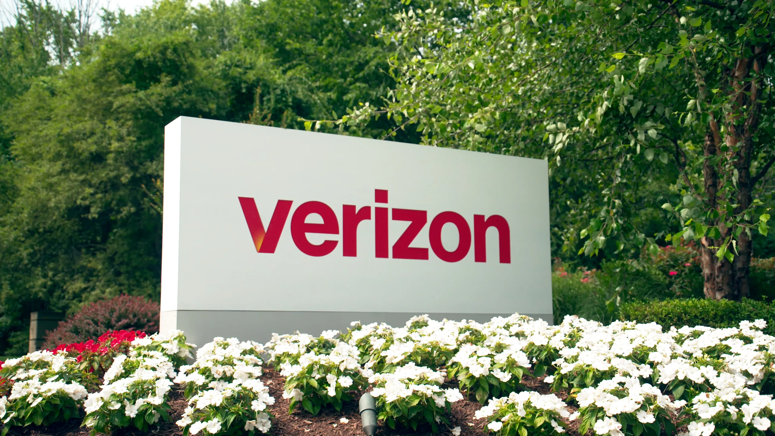 Verizon sign outside surrounded by greenery and flowers