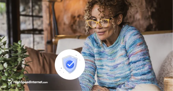 woman looking at laptop with an illustration of a shield and check mark to symbolize security