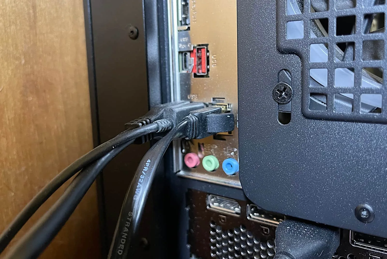 Backside of a computer showing an Ethernet cable plugged into the Ethernet port.