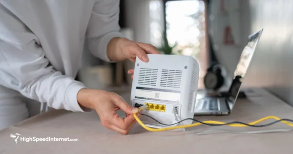 Person holding a router and plugging in cords