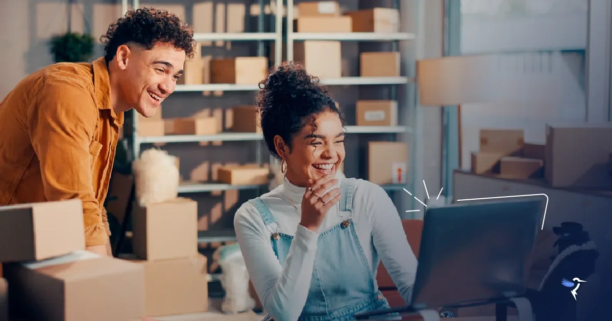 A man and a woman looking at a computer and smiling